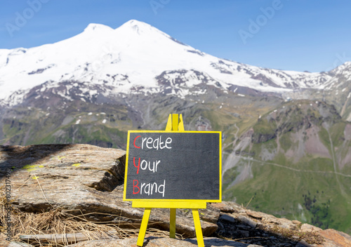 CYB Create your brand symbol. Concept words CYB Create your brand on beautiful yellow blackboard. Beautiful mountain Elbrus background. Business CYB Create your brand concept. Copy space. photo