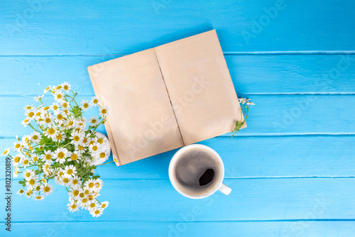 Chamomile daisy flowers bouquet, book, tea or coffee cup, relaxation holiday simple life enjoy summer background, on light blue wood background, top view copy space. Good day, good morning wishing © ricka_kinamoto