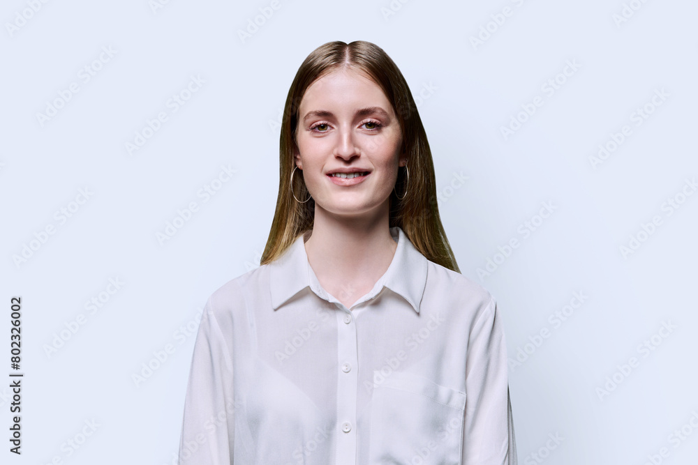 Portrait of teenage smiling female in white shirt on studio background Portrait of teenage smiling female in white shirt on studio background