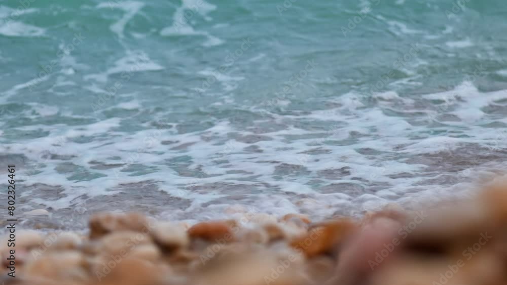 Close up view of waves lapping on a pebble Balearic seashore. Close up view of waves lapping on a pebble Balearic seashore.
