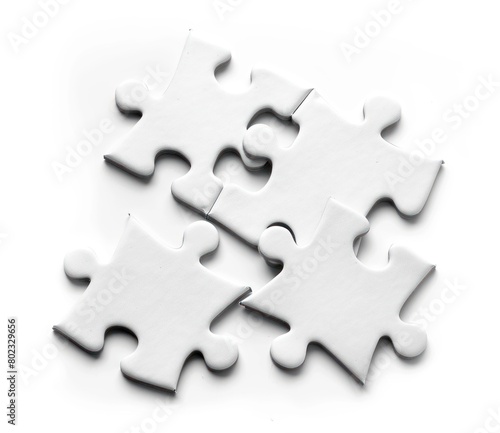 Puzzle pieces scattered on the table with a clean white background, closeup detail.
