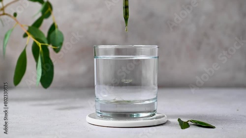 Chlorophyll extract is poured in pure water in glass. Liquid chlorophyll, superfood, healthy eating, detox and diet photo