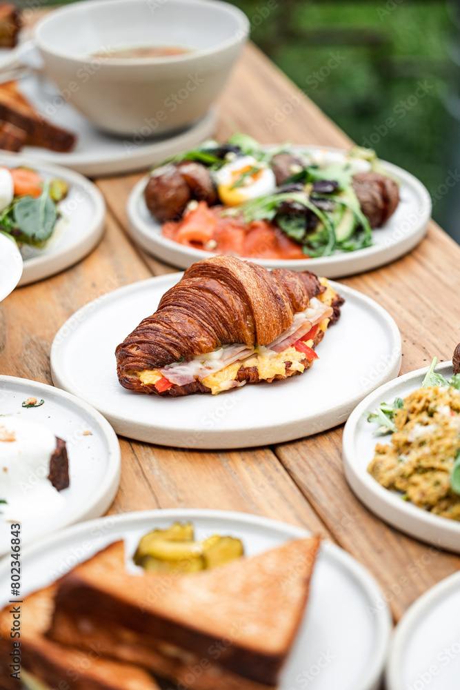 Gourmet Breakfast Spread Featuring Croissant Sandwich and Assorted Dishes Gourmet Breakfast Spread Featuring Croissant Sandwich and Assorted Dishes