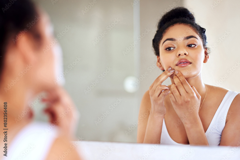Skincare, woman and mirror to pop pimple on face with hands, dirt or scar on skin in home. Dermatology, facial wellness and girl in bathroom to squeeze acne, checking reflection or morning routine