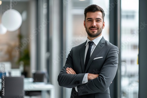 Confident businessman in a tailored suit standing in a modern office environment