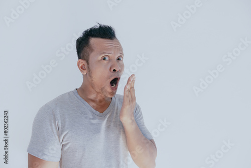 Funny face of bad breath Asian man on white background.