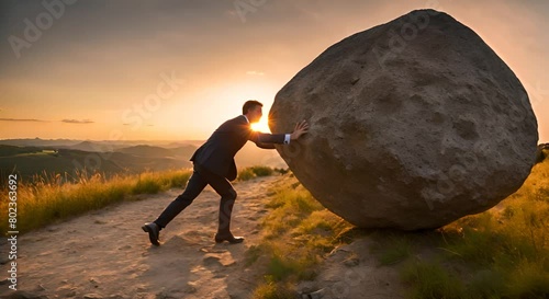 Businessman pushing a rock. photo