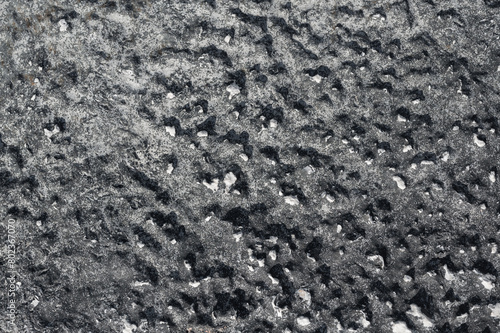 sfondo pietra superficie dura nera, grigia e bianca, roccia con avvallamenti, foto dall'alto, terreno irregolare photo