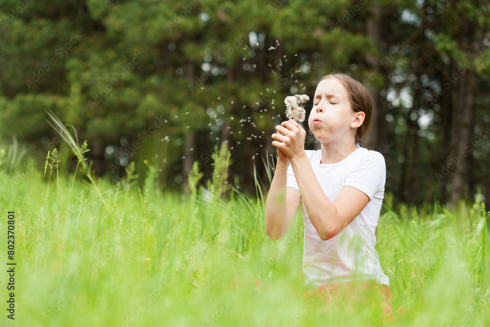 Young girl playing with dandelion in a grass field Young girl playing with dandelion in a grass field
