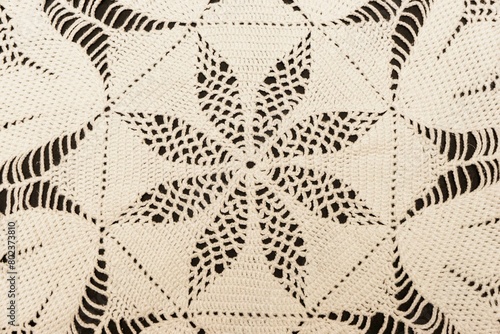 Vintage handmade white knitted napkin isolated on a black background.