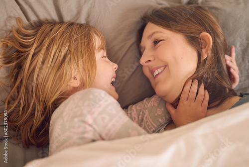 Mother, child and laughing on bed with love for relax, bonding together and fun weekend in family home. Mom, happy and young girl on mattress in house with smile, morning joke and funny in bedroom