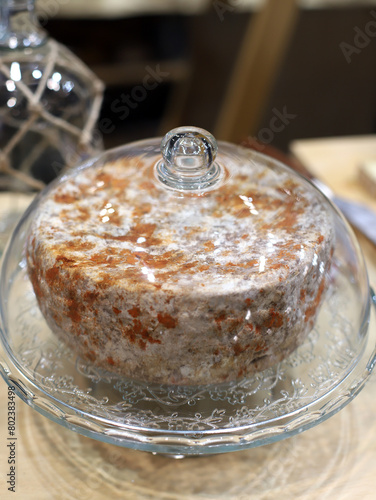 queso artesanal añejo especial con corteza con especias dentro de una cúpula de cristal