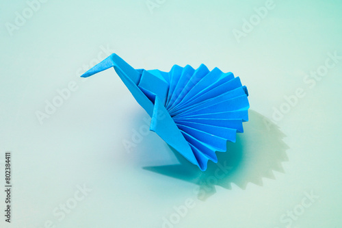 Blue colored isolated origami peacock.