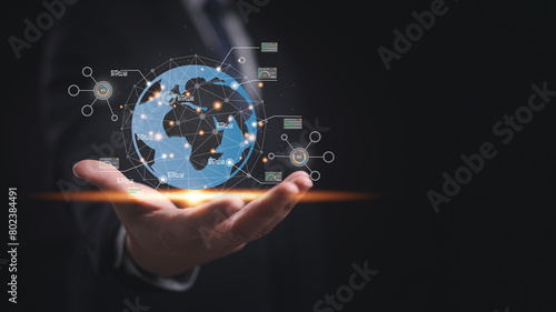 A man is holding a globe in hand that with network connection lines, dots and analysis graph in concept of AI analysis technology, innovation and worldwide business transformation.