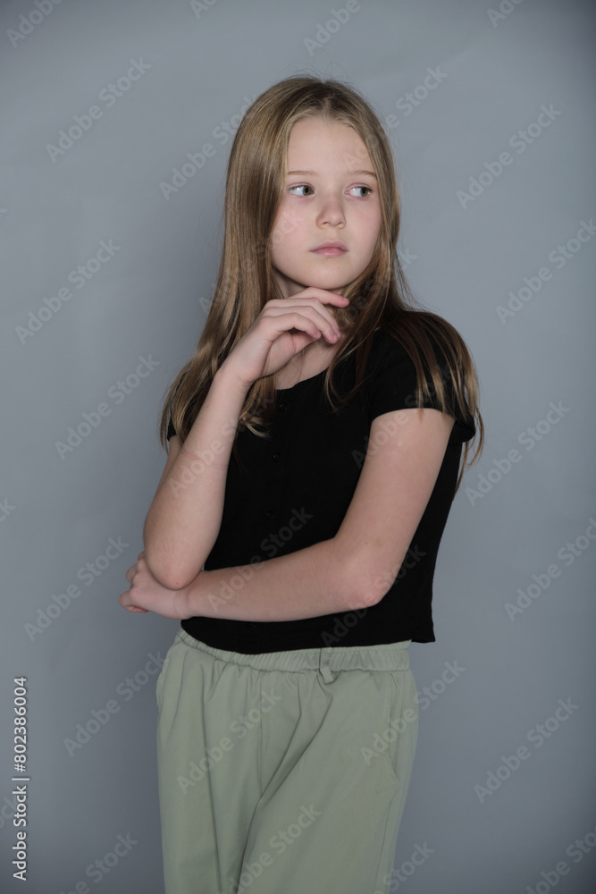 Pensive child with a gentle touch to her face, looking afar. Reflects the depth of young minds and their silent thoughts. Pensive child with a gentle touch to her face, looking afar. Reflects the depth of young minds and their silent thoughts.