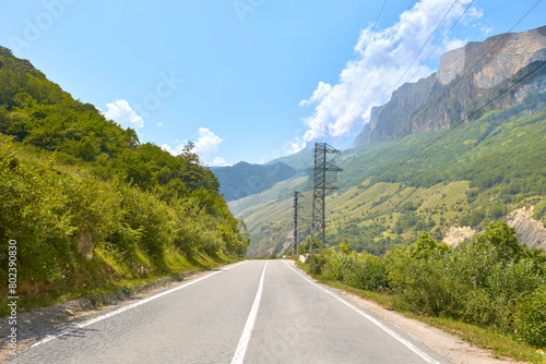 A beautiful road among green mountains and rocky peaks. Asphalt road in the direction to the village of Upper Balkaria.