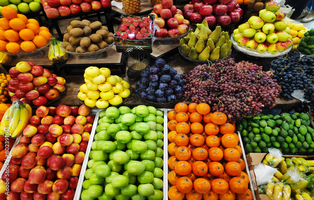 Apples, pears, pomegranates, bananas, oranges, grapes, kiwis, persimmons and other fruits on display at the market