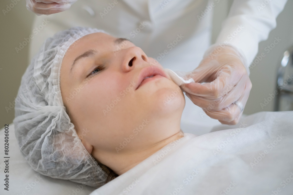 The cosmetologist's precise handwork preps for facial treatment. This step is vital for the success of cosmetic enhancements.