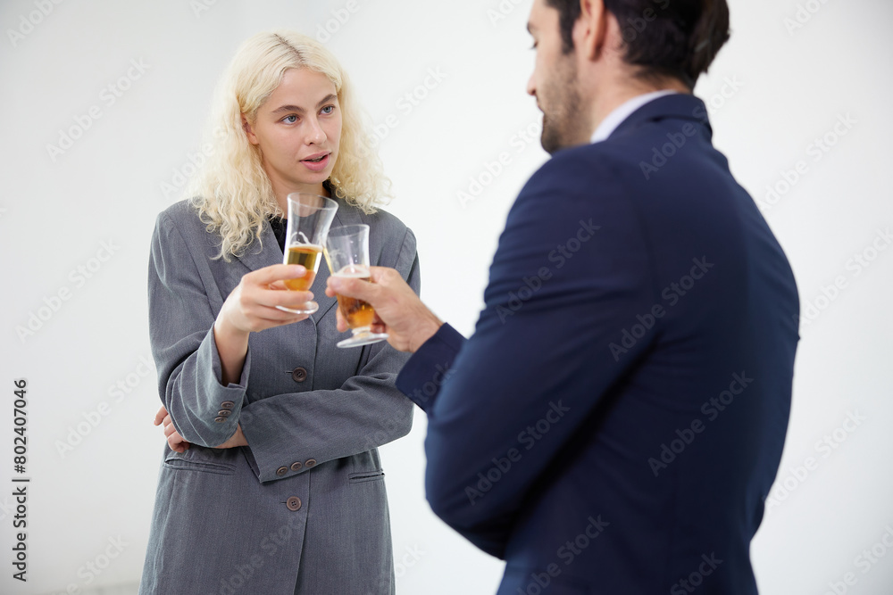 businesswoman talking with businessman drinking beer and clinking glasses in the office businesswoman talking with businessman drinking beer and clinking glasses in the office
