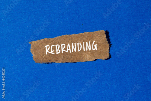 Rebranding word written on ripped paper piece with blue background. Conceptual rebranding symbol. Copy space. photo