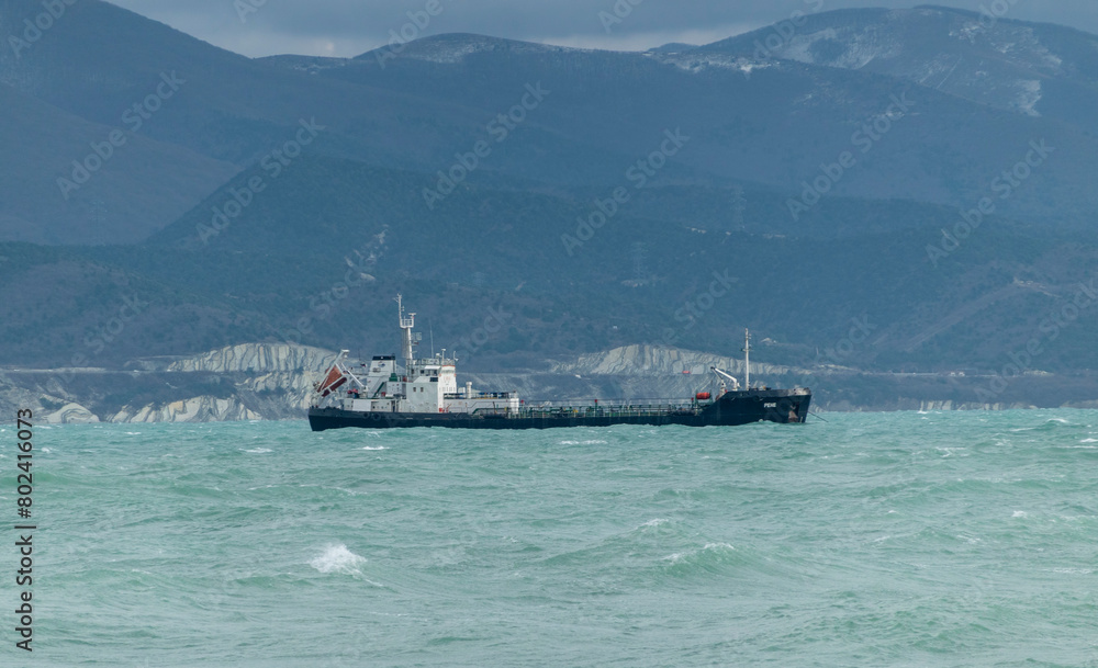 Sea freighter sailing in the middle of the ocean with big waves.