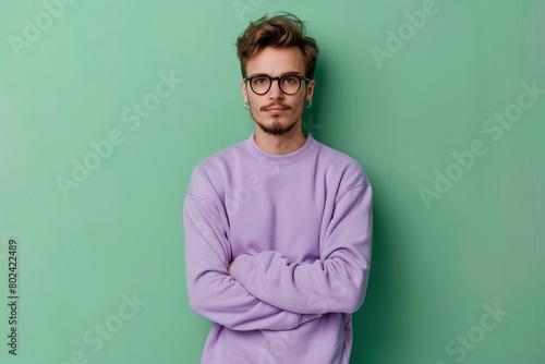 Young attractive man in sweatshirt on green background