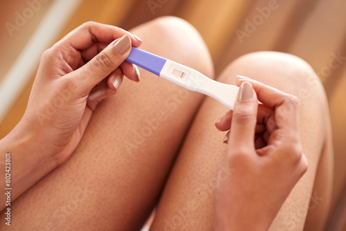 Woman  hands and pregnancy test with negative results of line  stick or examination at home. Closeup of female person waiting in motherhood with maternity exam for impregnation sign or expectation