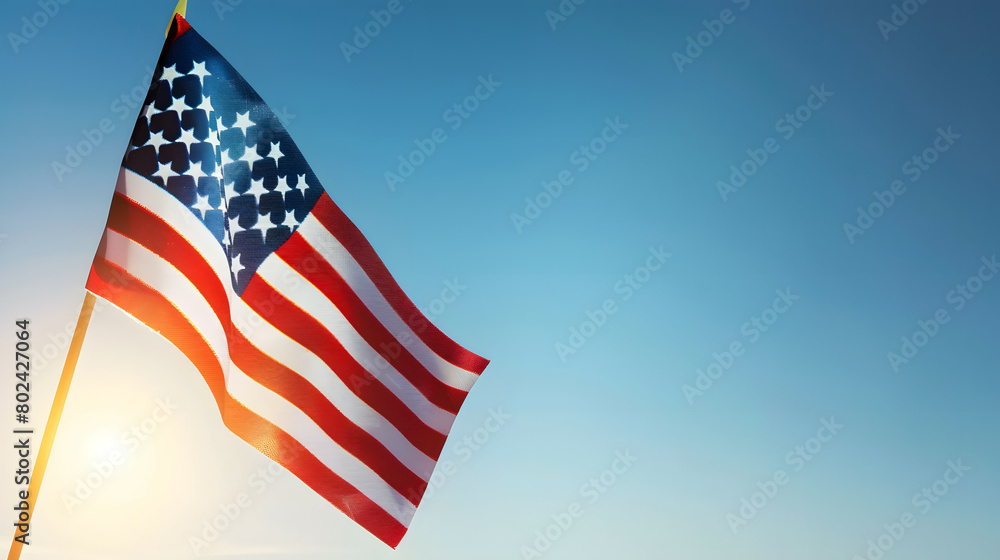 Fototapeta premium Closeup shot of a small American flag with background of blue sky.
