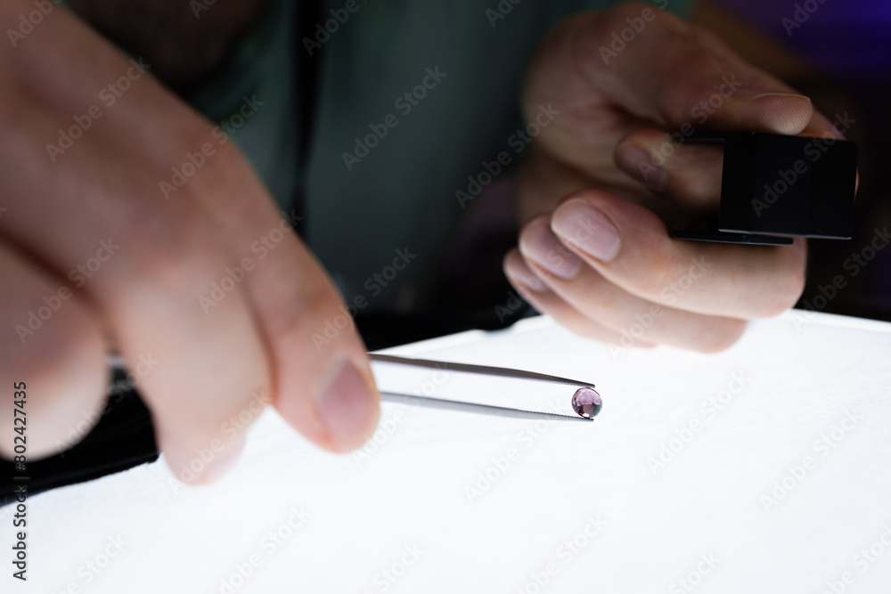 A gemmologiste studying an amethyst A gemmologiste studying an amethyst