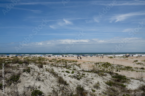 People at a distance enjoying day at ocean beach