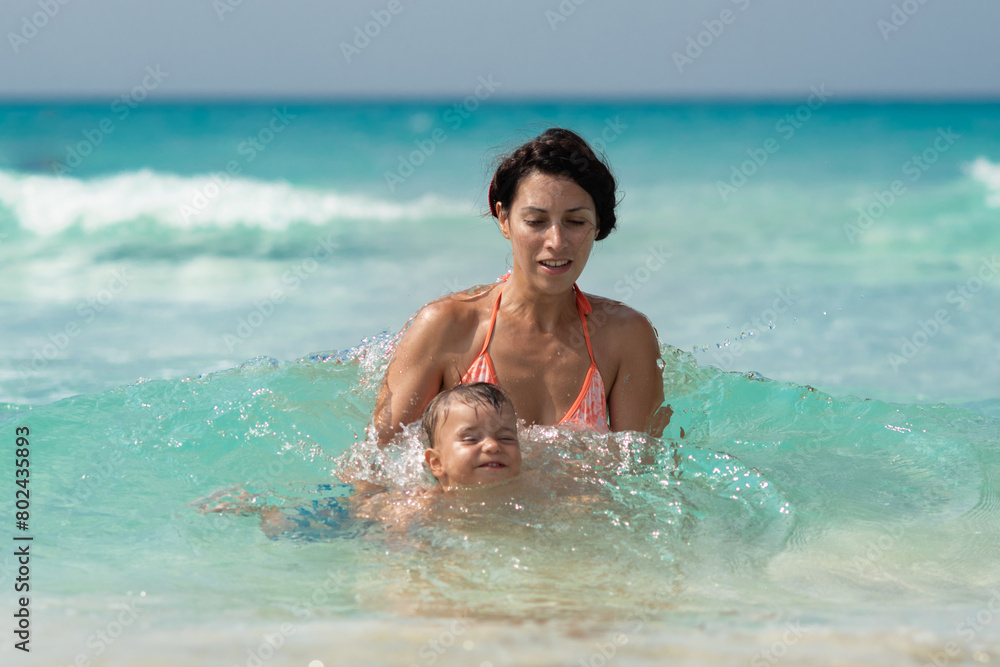 sea, summer, vacation, family on the beach, swimming in the ocean, vacation in warm countries, Caribbean sea, Atlantic ocean, Cuba, mother carrying a child, mother and baby on vacation