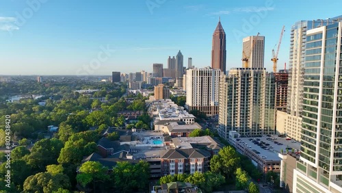 4K drone footage flying over trees and buildings towards Atlanta's skyline.  Footage near Midtown Atlanta.  Smooth drone video displaying green tree tops and sprawling skyscrapers