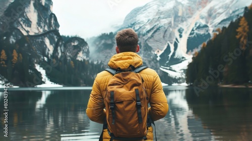 Male hiker looking at view feeling at peace in mountain forest lake settings 