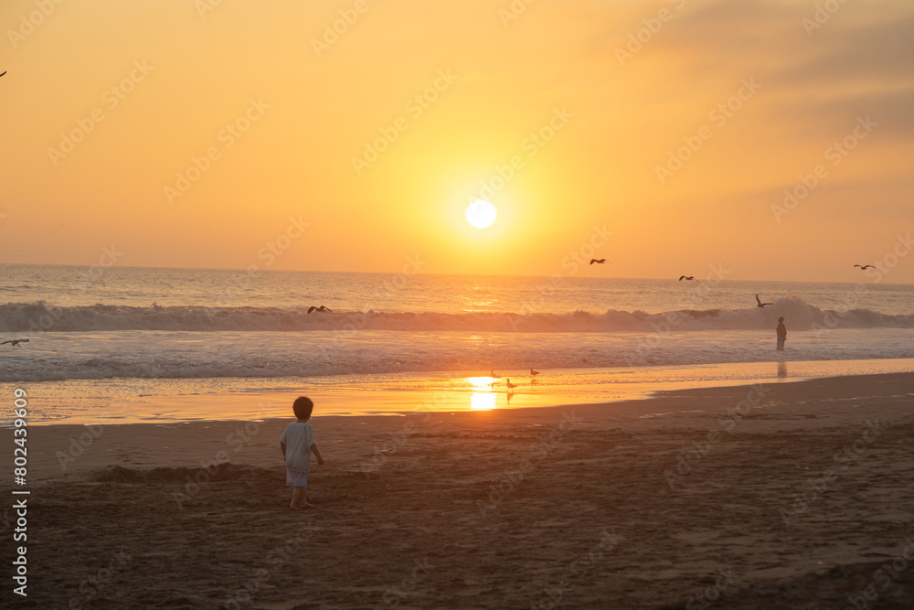 Little boy playing in sand at the beach during vacations in Peru