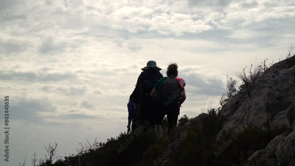 Slow motion, silhouette of people hiking outdoors, on a cloudy morning. Slow motion, silhouette of people hiking outdoors, on a cloudy morning.