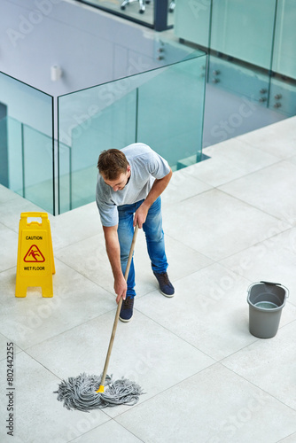 Foto Man, janitor and mopping office floor or cleaning hygiene with caution sign or water, soap or bacteria