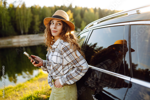 Happy young woman driver traveler using smartphone during travel. Travel, weekend concept.