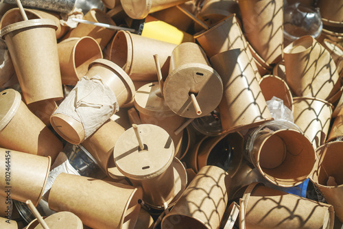 Eco-friendly disposable brown paper cups and plastic glasses used from coffee cafe, restaurants, takeaways. Disposal garbage waste recycle. Close up.