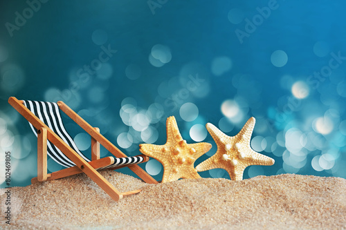 Deckchair and starfish on the sandy beach. Summer time.