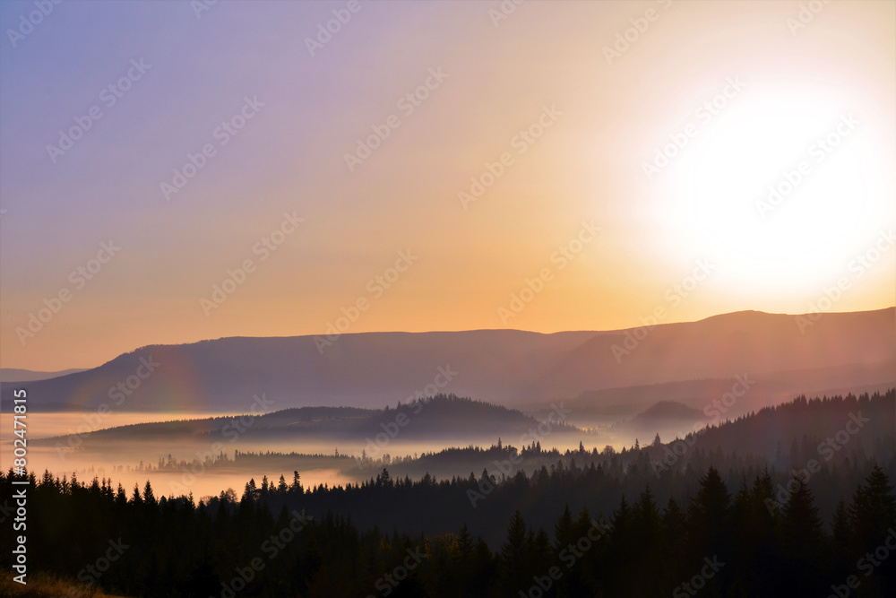 Beautiful landscape with a sunrise over the mountains with fog in the valley
