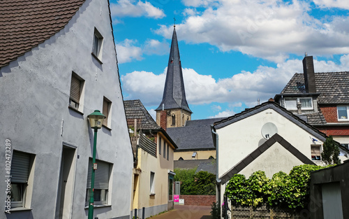 Grefrath (NRW), Germany - May 1. 2024: Street with old houses in the direction of the church (focus on center)