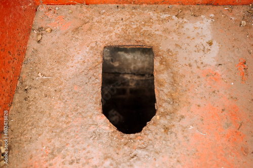 Photo of a hole in an old smelly dirty metal rusty rural toilet in Russia. Concept of poverty, poor. © shchus