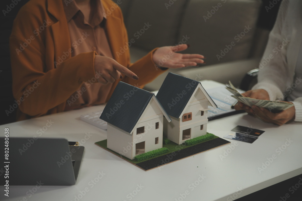 Discussion with a real estate agent, House model with agent and customer discussing for the contract to buy, get insurance or loan real estate or property. Discussion with a real estate agent, House model with agent and customer discussing for the contract to buy, get insurance or loan real estate or property.