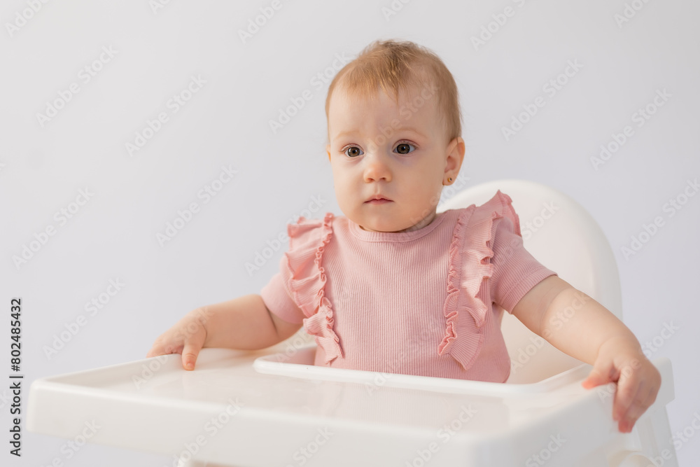 cute baby in a baby chair on a white background cute baby in a baby chair on a white background
