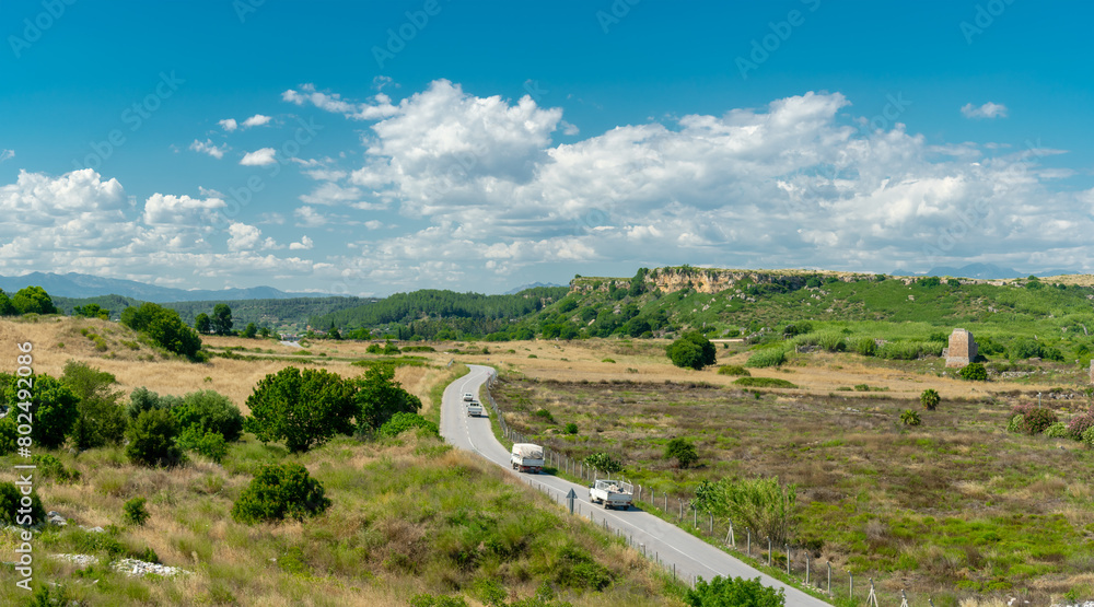 View from a height of the ancient city of Perge. Ancient city surrounded by dense green vegetation. View from a height of the ancient city of Perge. Ancient city surrounded by dense green vegetation.