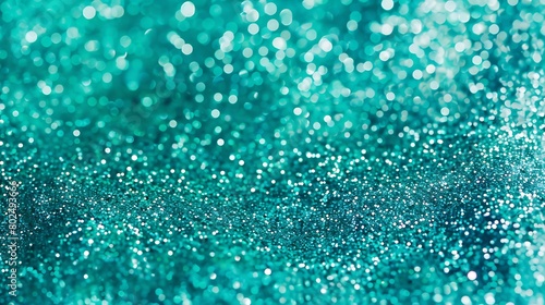 A close-up image of a glittering turquoise surface with a bokeh effect creating a textured sparkling background. 