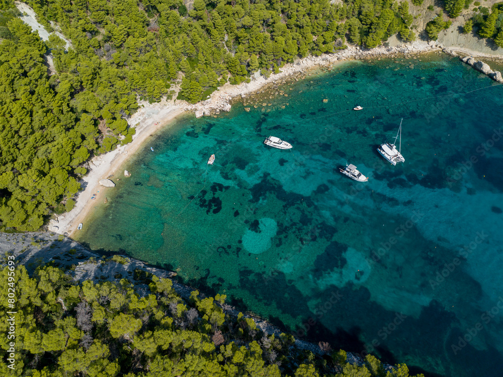 AERIAL: Scenic shot of couple of boats anchored in a peaceful bay of Hvar island