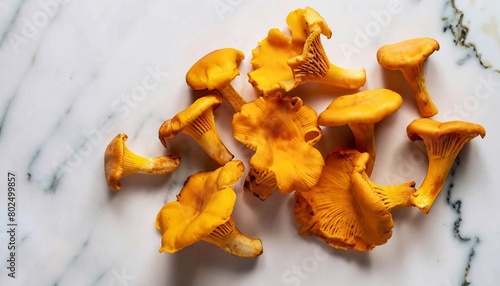 macro shot of scattered chanterelle mushrooms on a white marble table top view