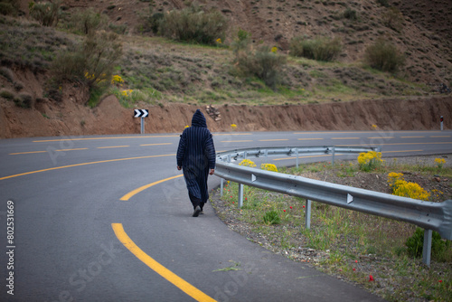 Moroccan man dressed in djellaba walking down the road