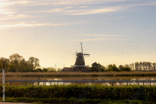 Countryside landscapes of polder in spring, The Molen Leonide along the Hooge Oude Veer river in Anna Paulowna, Traditional Dutch windmill with warm sunlight in the morning, Noord Holland, Netherlands photo